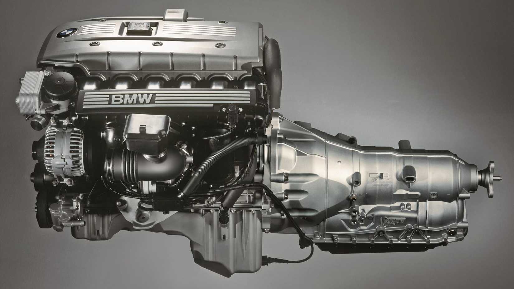 BMW inline-six engine closeup, plain background, with transmission