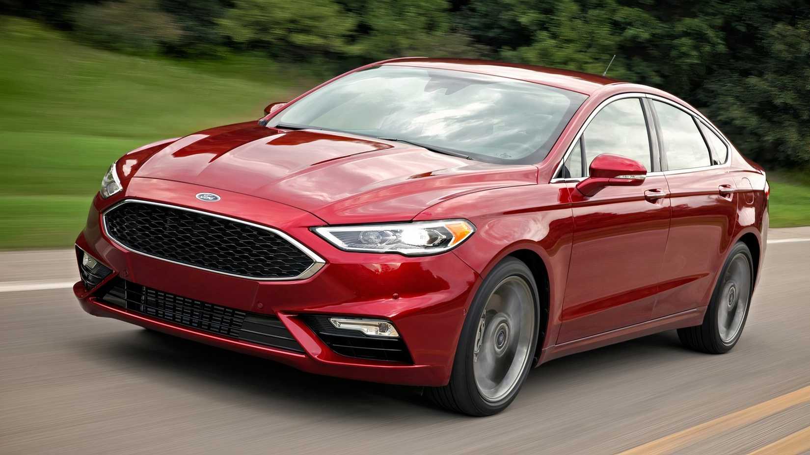 Uma vista frontal vermelha do Ford Fusion Sport 2017 enquanto ele dirige por uma estrada secundária