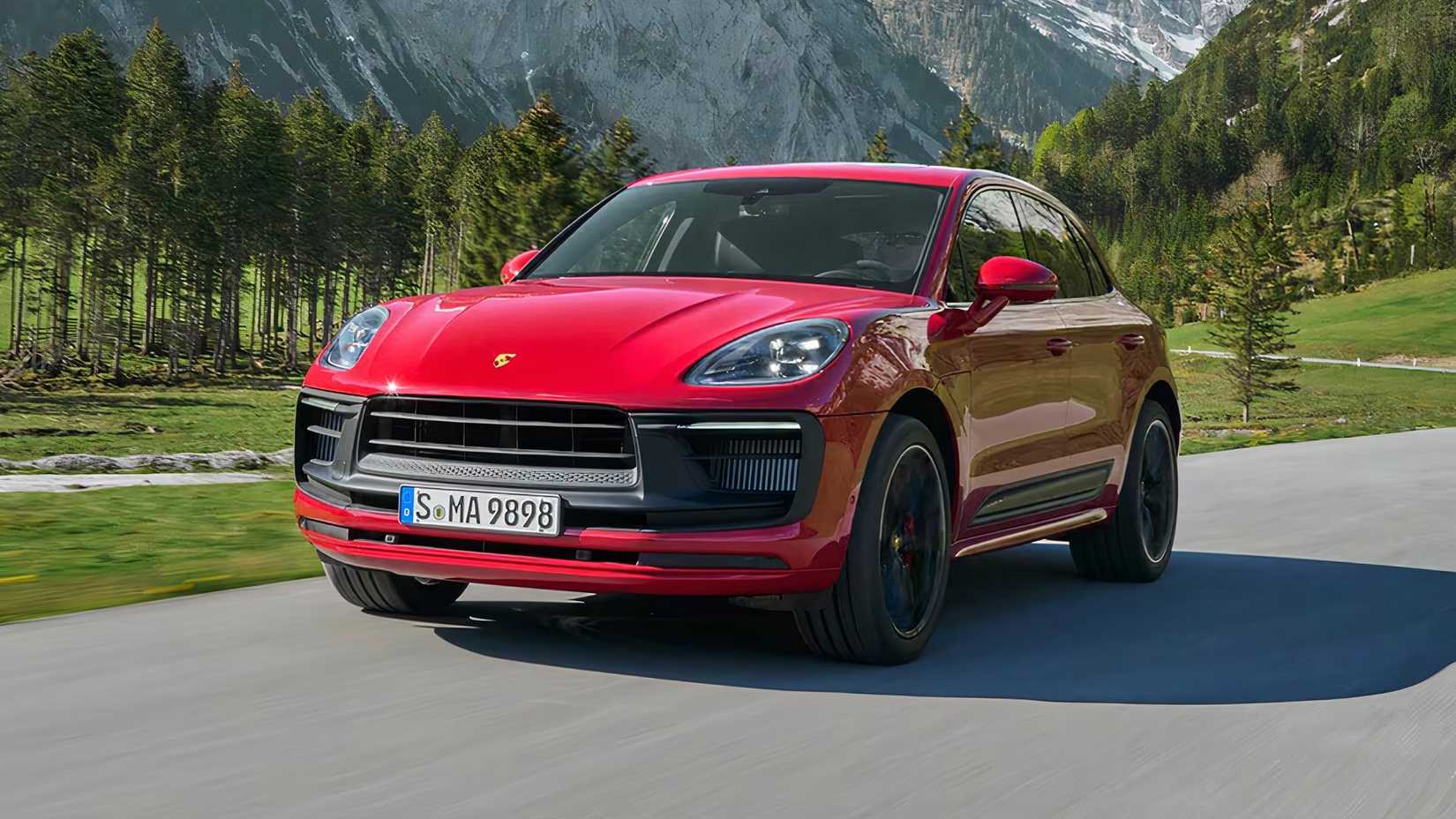 2025 Porsche Macan GTS em vermelho dirigindo em estrada secundária com montanhas ao fundo