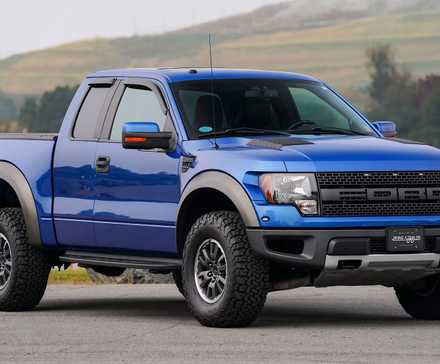 2010 Ford F-150 SVT Raptor SuperCab em azul estacionado em frente ao lago