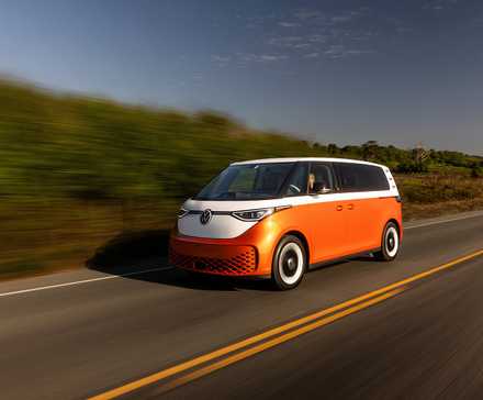 2025 Volkswagen ID. Buzz in orange and white driving on road
