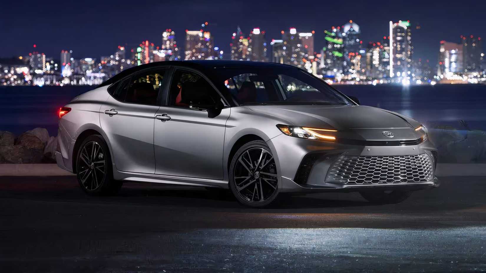 2025 Toyota Camry em prata estacionado em frente à cena da cidade