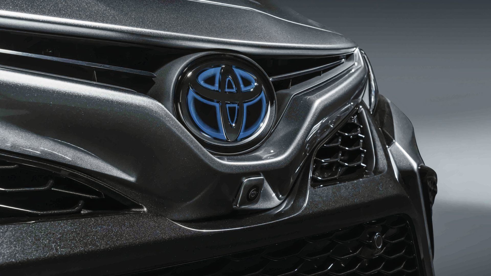 Close-up do emblema dianteiro híbrido do Toyota Camry XSE 2022