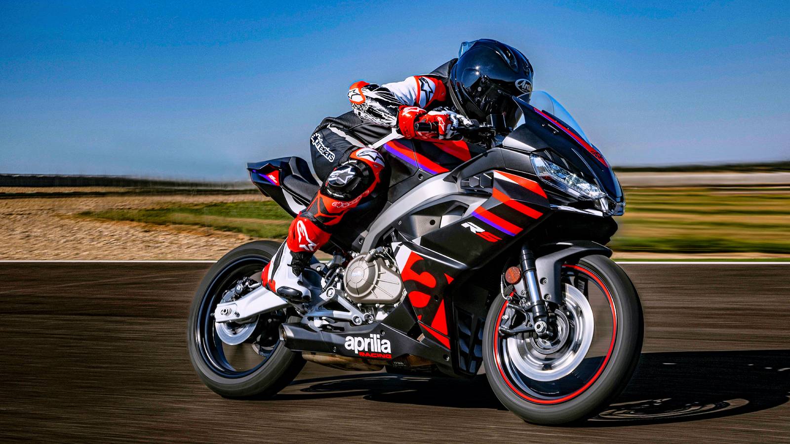 Aprilia RS 457 in strada, con luce LED e design sportivo, in posizione di guida