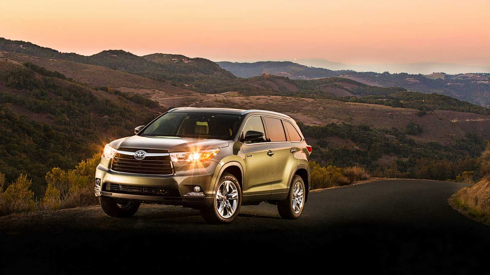 Toyota Highlander Hybrid with its headlights on. 