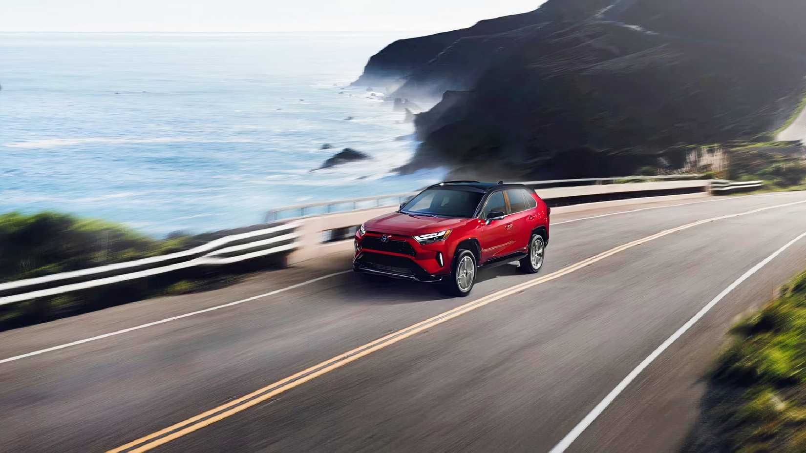 A red Toyota RAV4 Plug-In Hybrid driving on the road