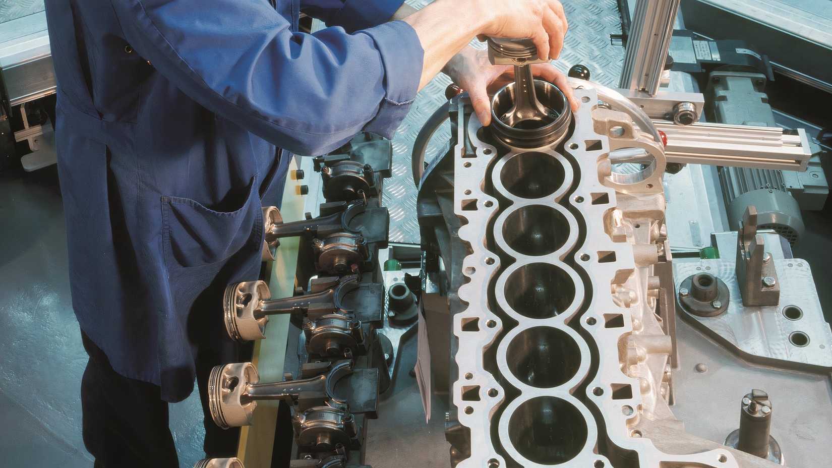 BMW engine - inline-six in factory, partly dissasembled, man working
