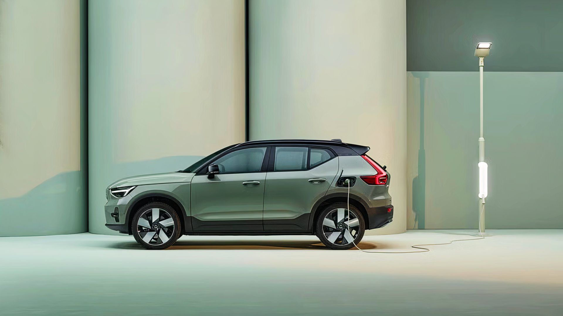 A green Volvo XC40 Recharge SUV is charging. 