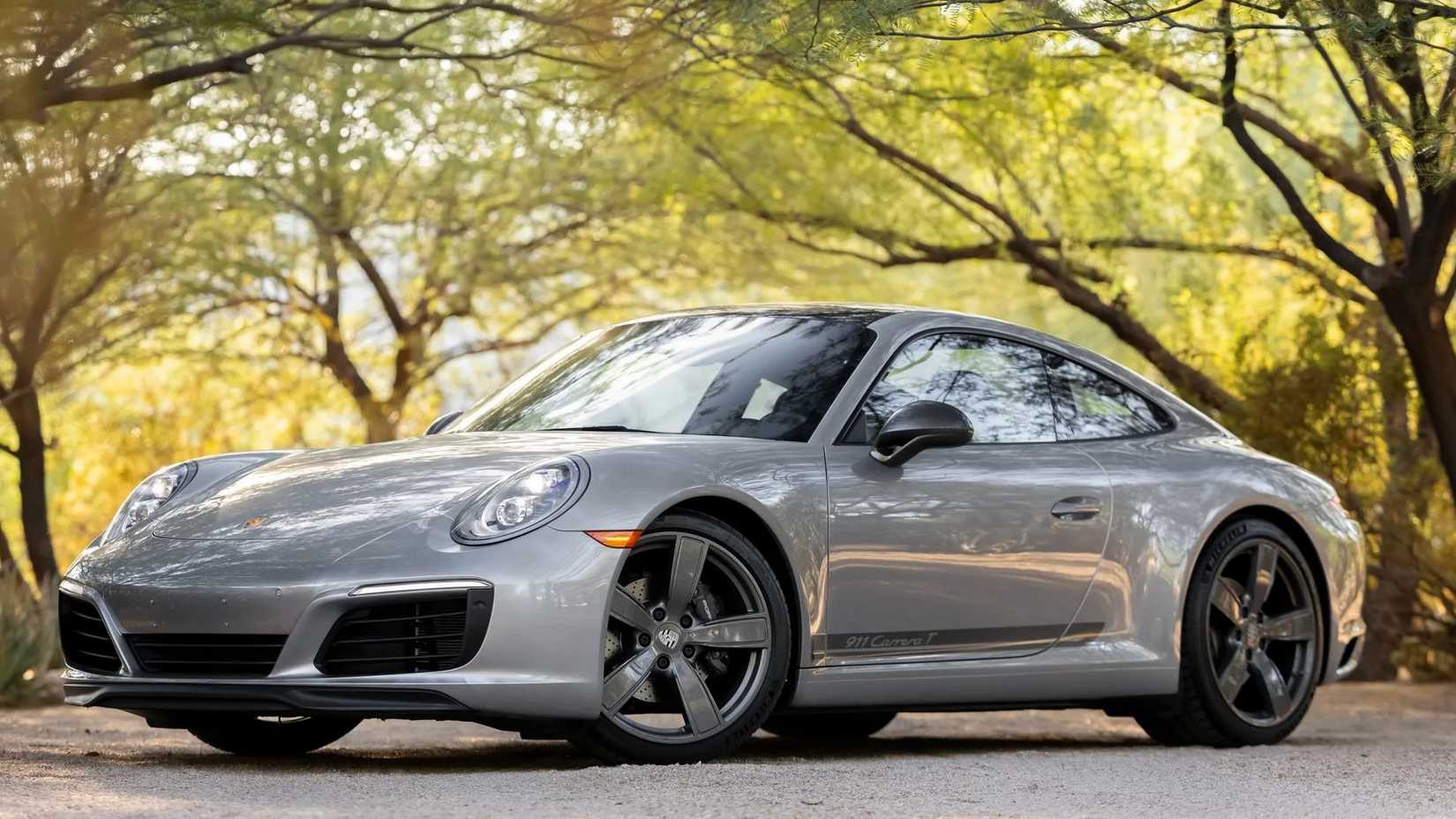 A front 3/4 still shot of a grey 2018 Porsche 911 Carrera parked on the road