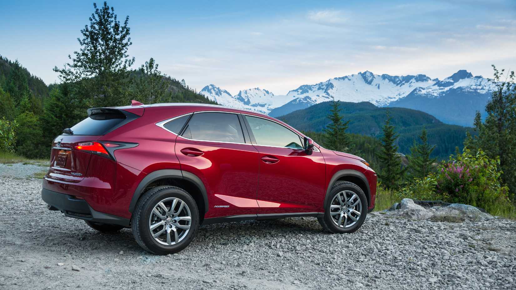 2020 Lexus NX 300h no penhasco com vista para as montanhas. Perfil lateral.