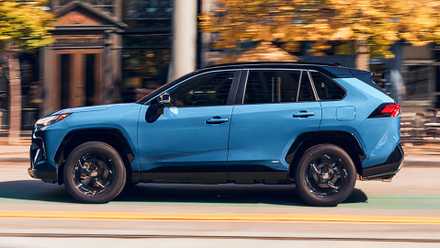 Um pequeno SUV híbrido Toyota RAV4 Hybrid 2022 azul está dirigindo.