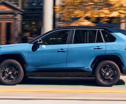 A blue 2022 Toyota RAV4 Hybrid small hybrid SUV is driving.