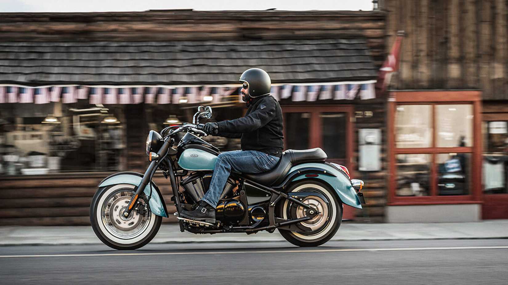Vulcan 900 Classic pilotado em uma rua da cidade com um prédio ao fundo