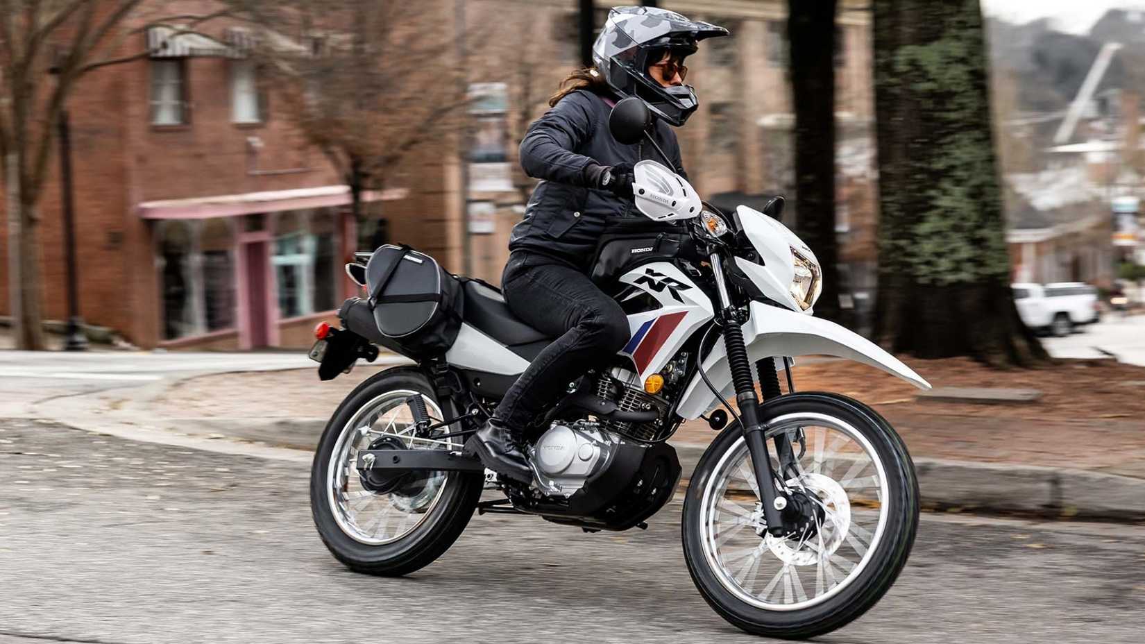 Honda XR150L carregada de acessórios fazendo curvas em uma estrada urbana