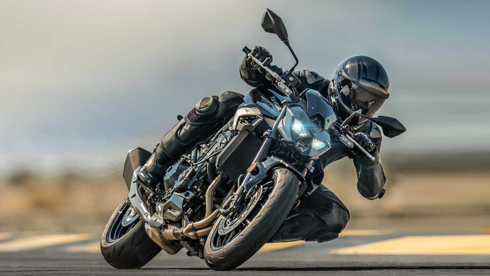Piloto fazendo curvas agressivamente em uma Kawasaki Z900
