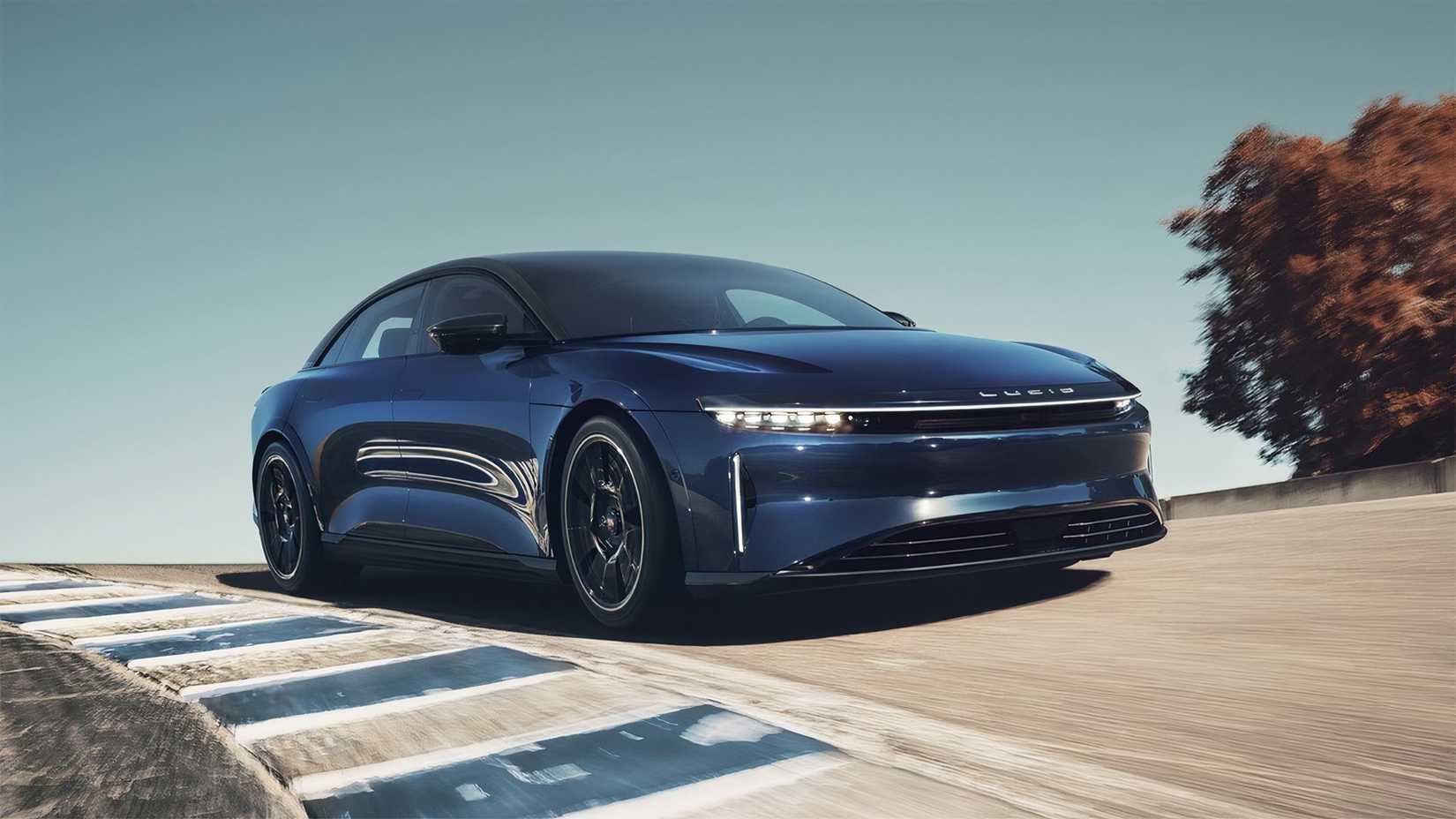 Driving shot of a blue Lucid Air Sapphire on a race track in front 3/4 view