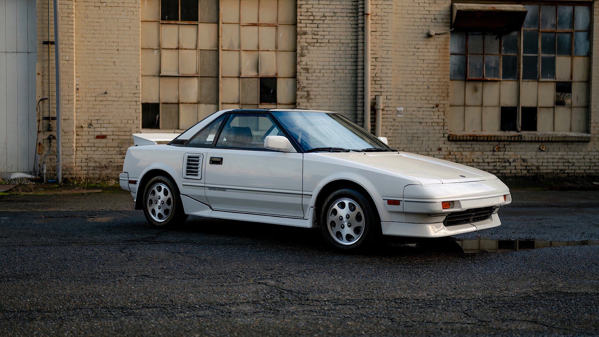 1988 Toyota MR2 in white parked in front of warehouse