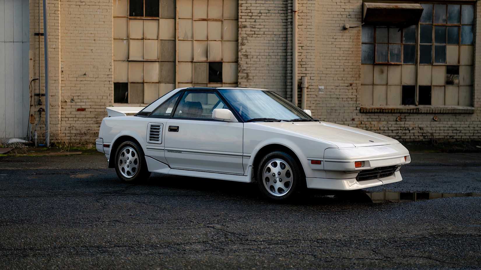 1988 Toyota MR2 em branco estacionado em frente ao armazém