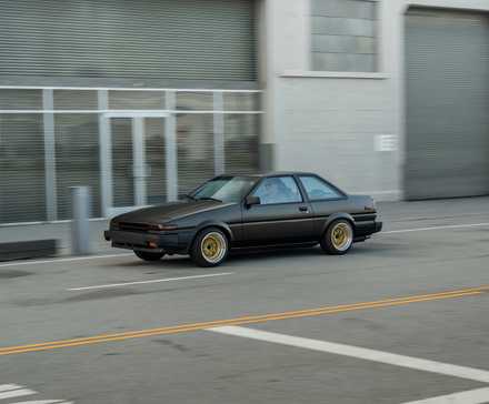1986 Toyota AE86 Corolla em preto dirigindo na estrada