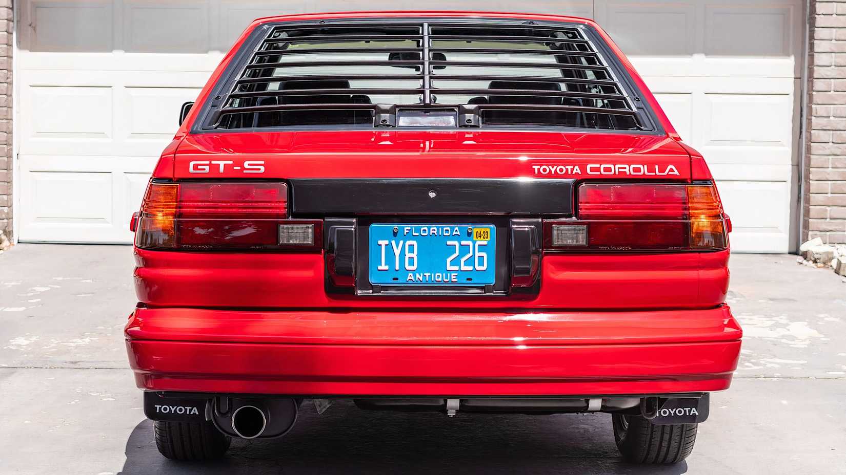Foto traseira de um Toyota AE86 Corolla GT-S 1987 em vermelho estacionado na garagem
