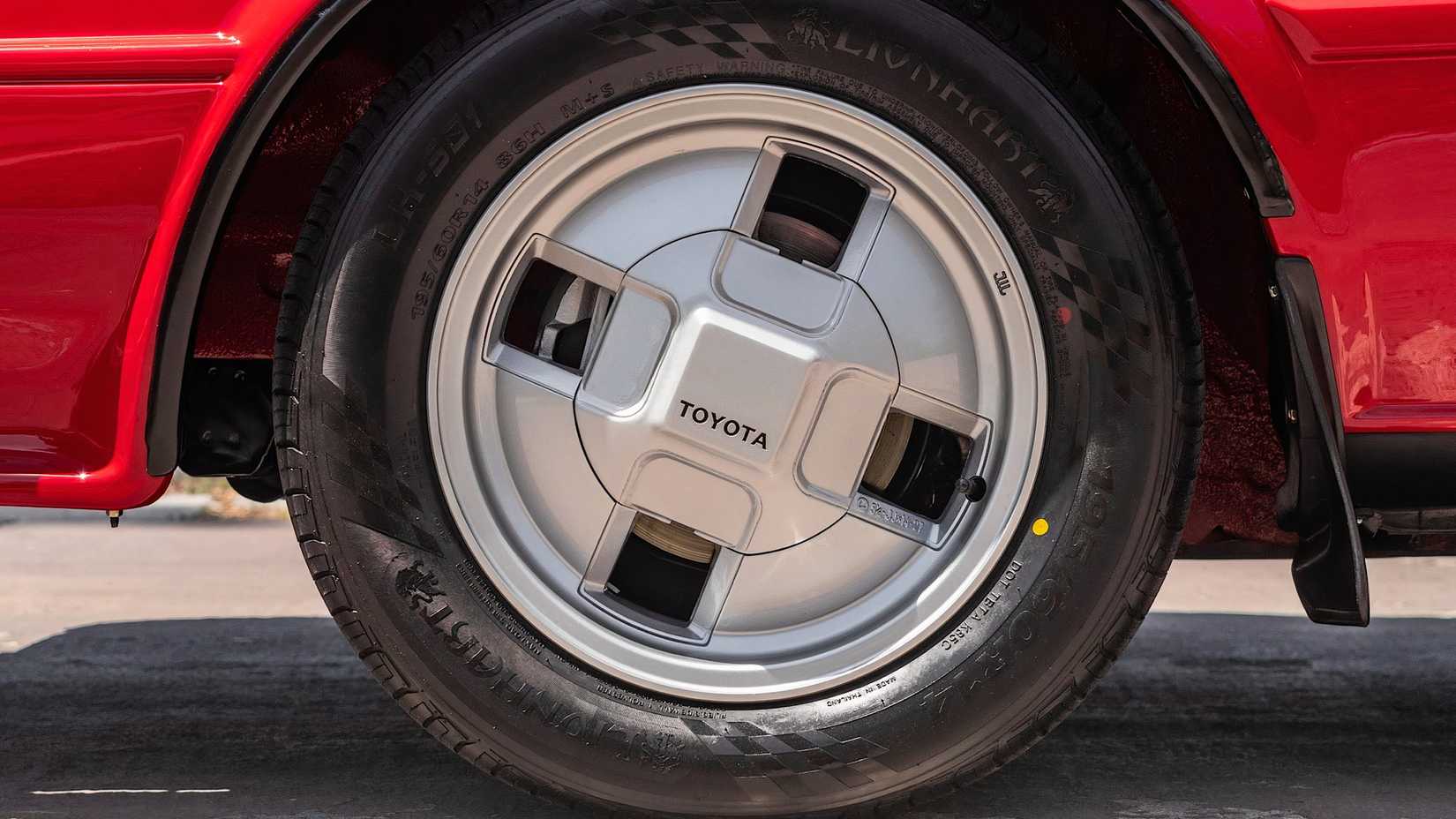 Um close-up de uma roda vermelha do Toyota AE86 Corolla GT-S 1987