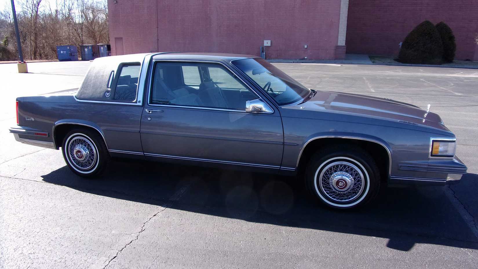 Cadillac DeVille 1987 em cinza estacionado em um estacionamento