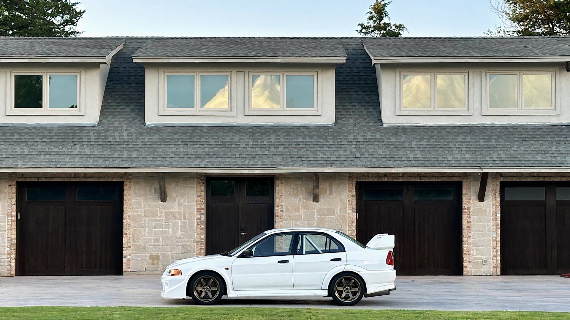 1999 Mitsubishi Lancer Evolution VI GSR in white parked outside of garages