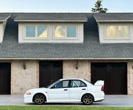 1999 Mitsubishi Lancer Evolution VI GSR in white parked outside of garages