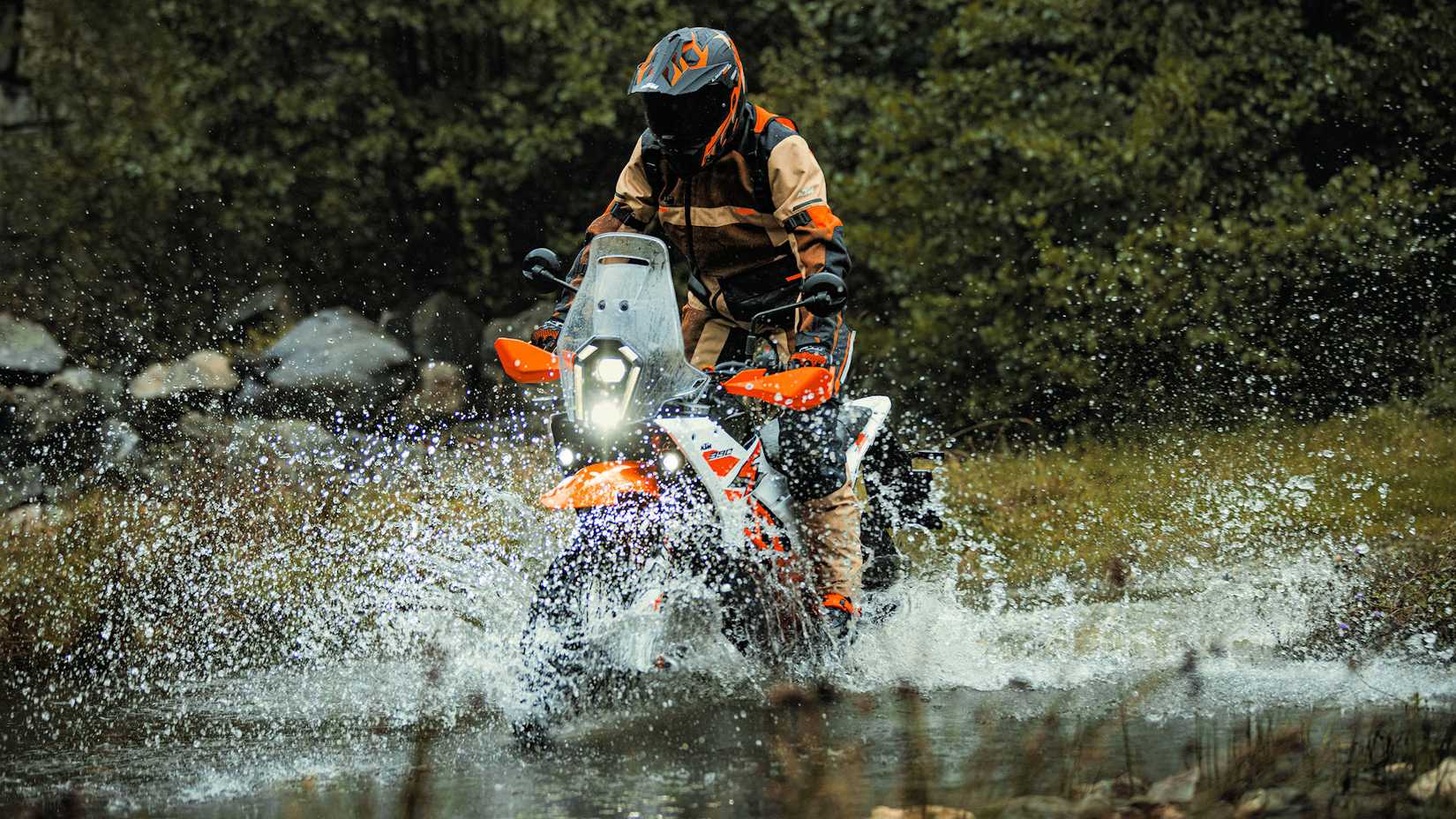 Piloto em uma KTM 390 Adventure R 2025 atravessando um riacho
