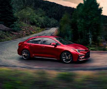 A red Toyota Corolla Hybrid small hybrid car.