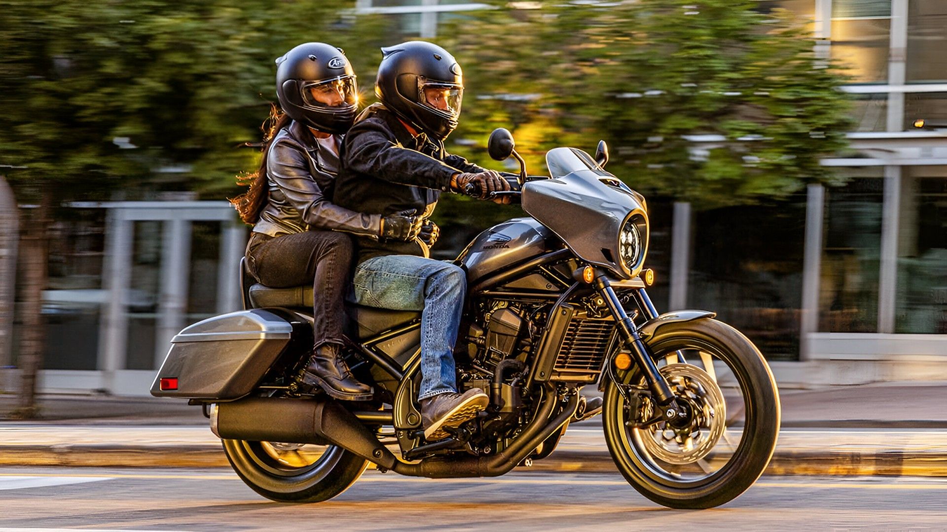 Honda Rebel 1100T navegando na cidade com vista de perfil lateral do passageiro
