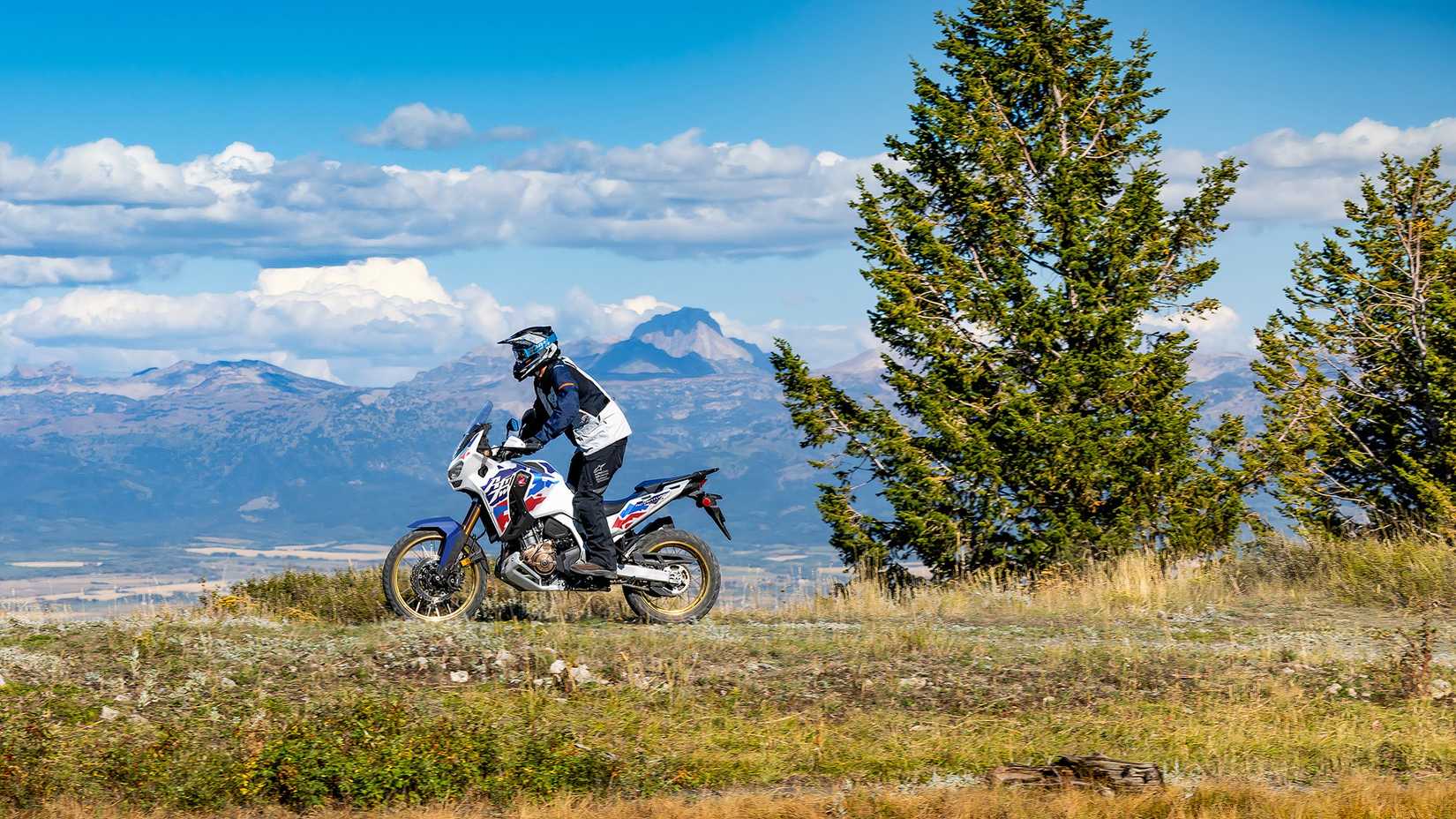 Side shot of a Honda Africa Twin Adventure Sports ES riding off-road in front of mountain