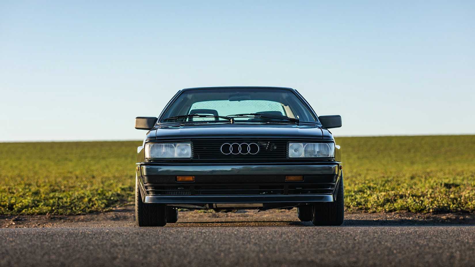 1985 Audi Quattro 20V in black parked in front of field