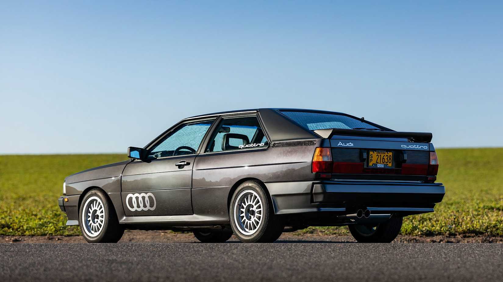 1985 Audi Quattro 20V in black parked in front of field