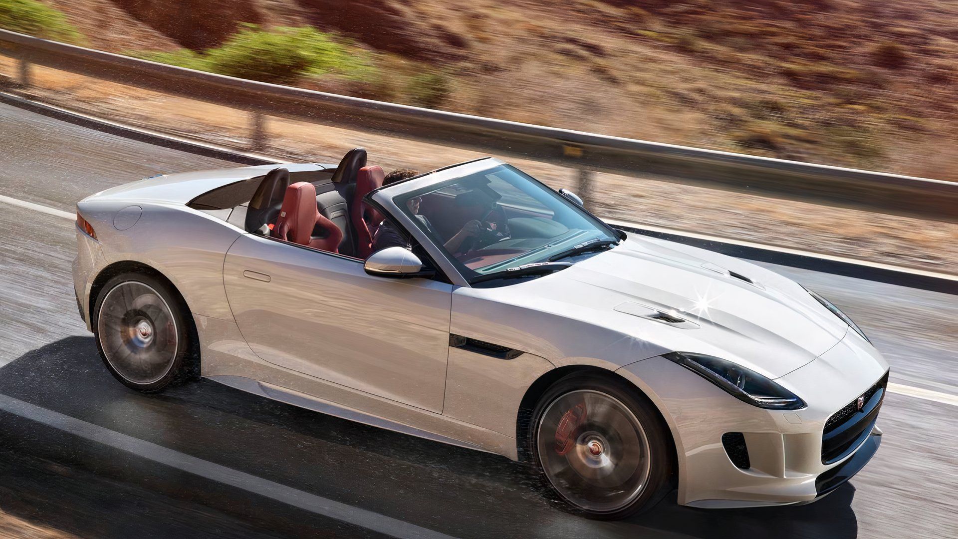 2017 Jaguar F-Type R in silver driving with roof down on mountain road