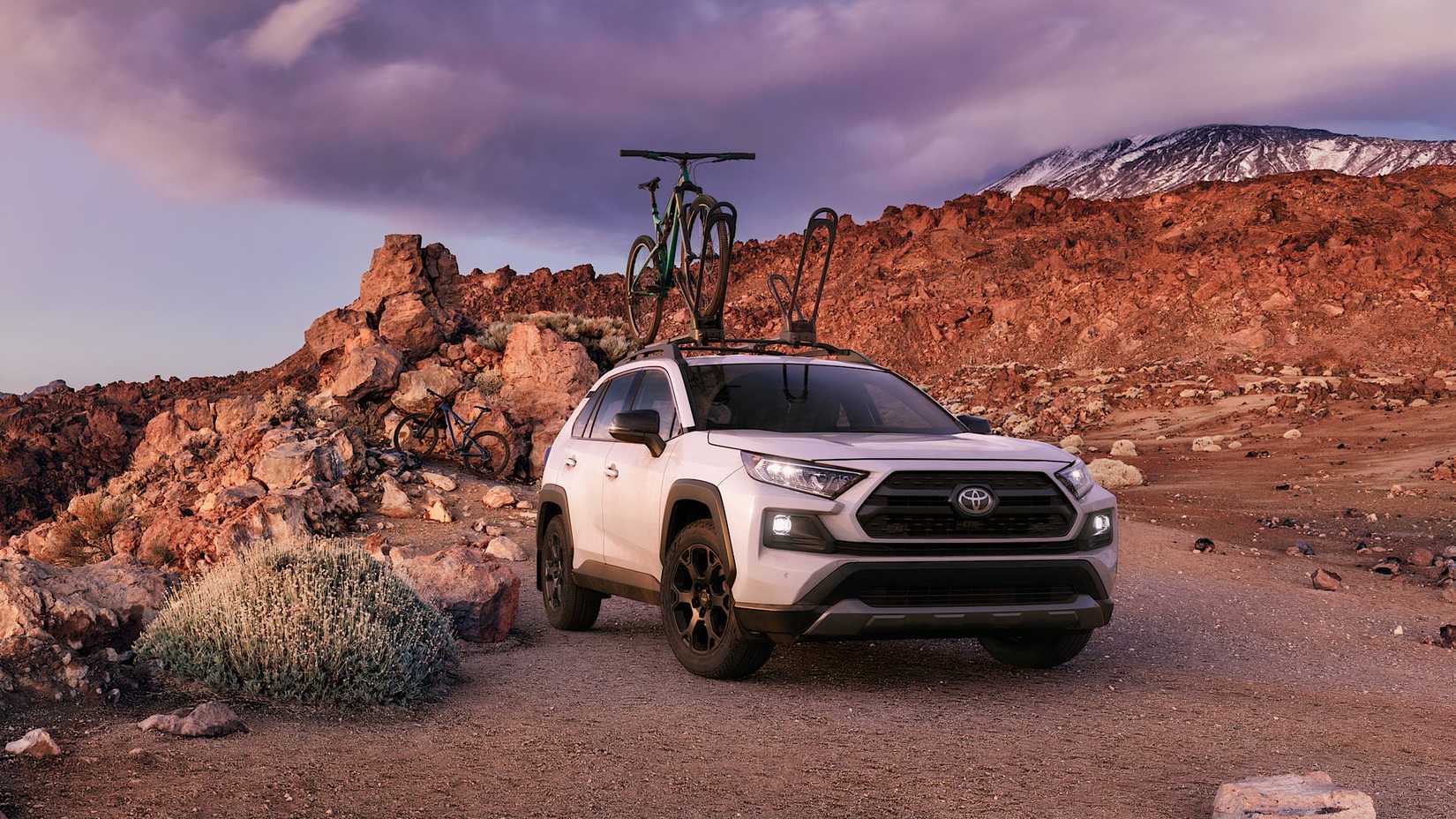 2020 Toyota RAV4 in white parked off-road with bike on roof