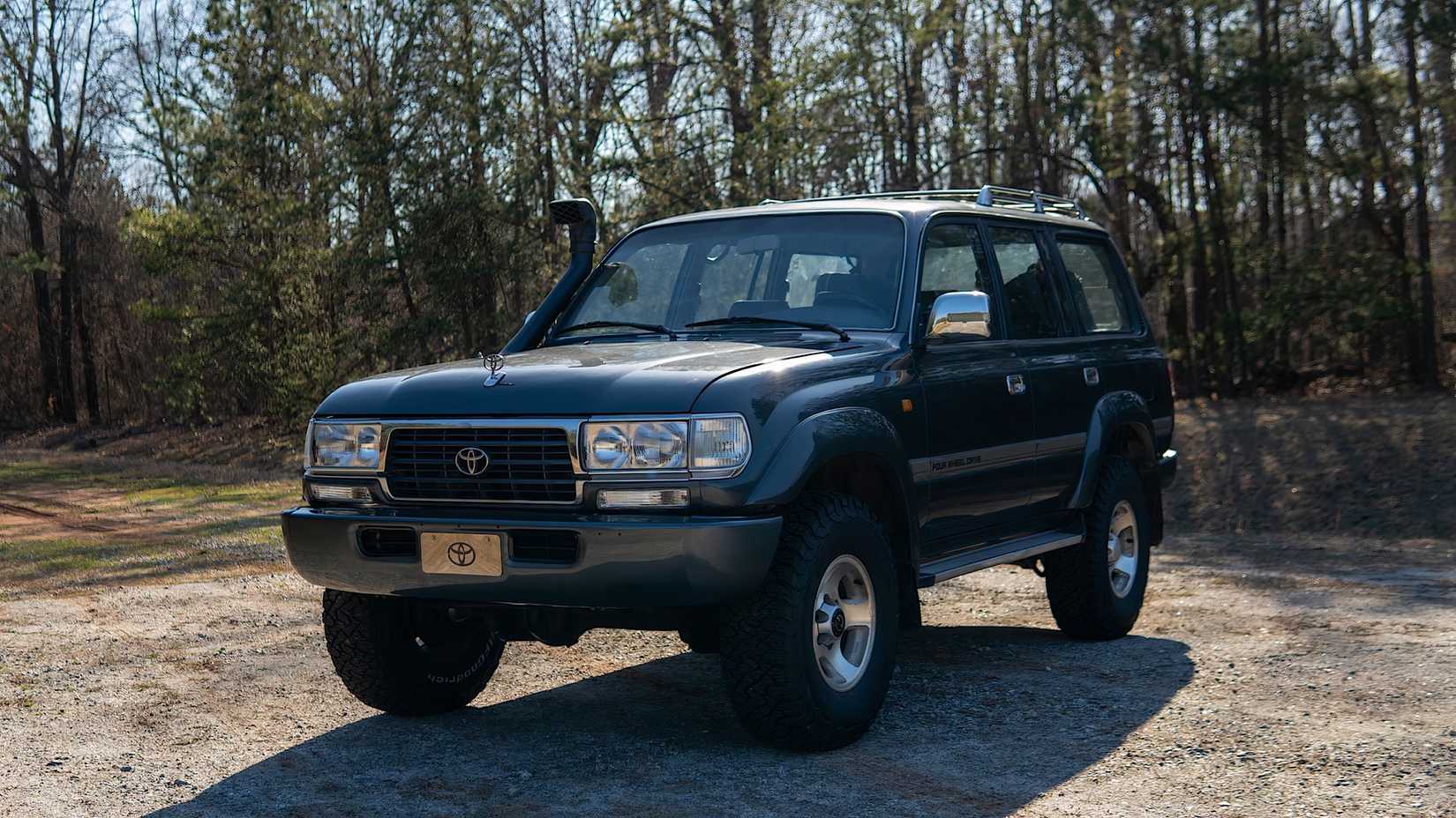 1992 Toyota Land Cruiser em preto estacionado sob árvores
