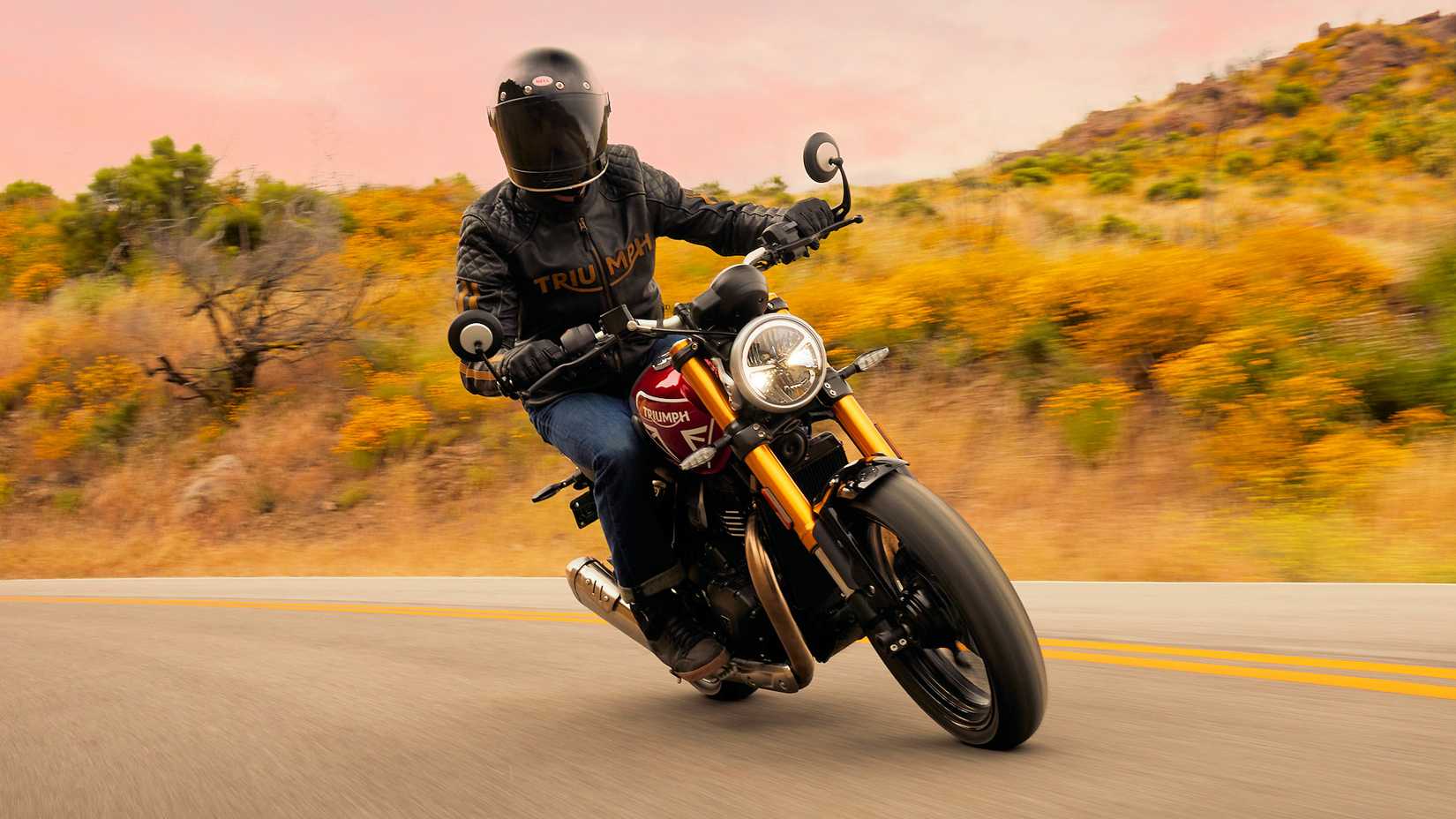 Rider on a Triumph Speed 400 cornering front third quarter view