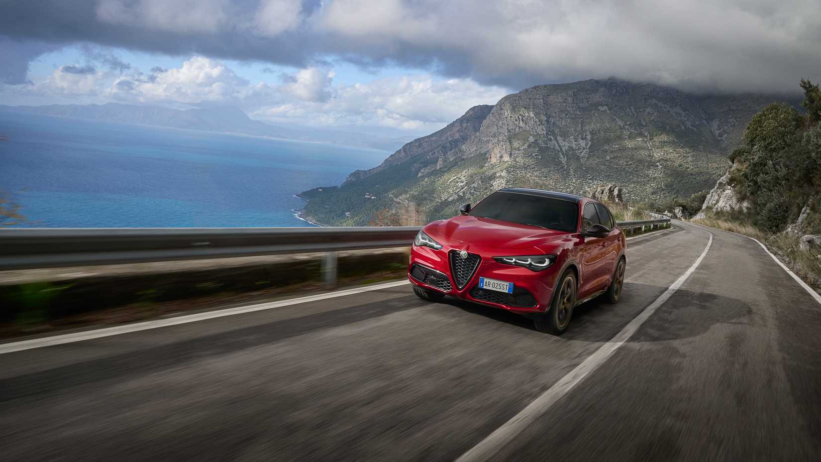 Foto frontal do Alfa Romeo Stelvio dirigindo ao longo da estrada costeira