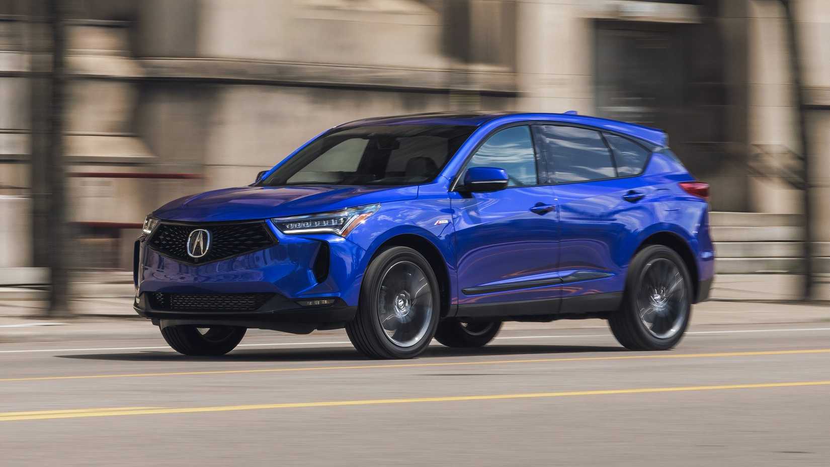 Front 3/4 shot of a blue 2024 Acura RDX driving through city