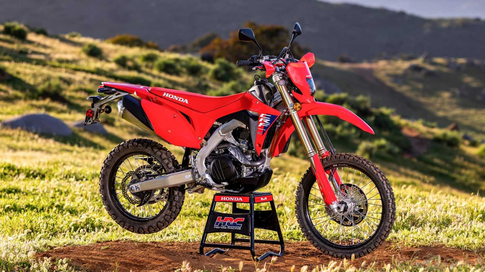 Foto cinematográfica do perfil lateral esportivo duplo da Honda CRF450RL