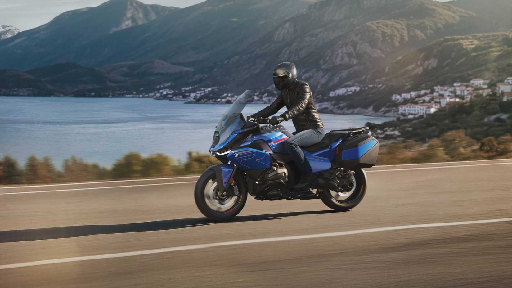 2026 BMW R 1300 RT sendo conduzida em uma estrada costeira com o mar ao fundo