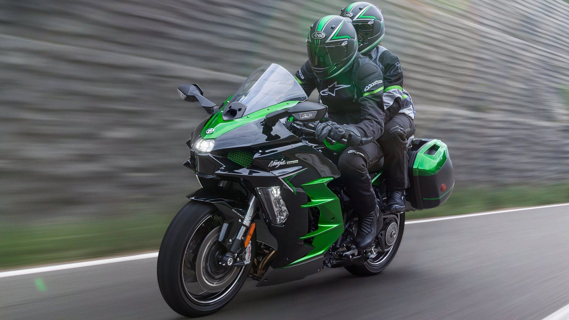 2025 Kawasaki Ninja H2 SX touring bike accelerating wildly front third quarter view