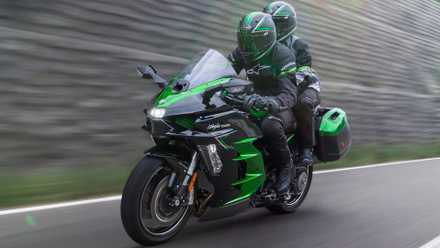 2025 Kawasaki Ninja H2 SX touring bike accelerating wildly front third quarter view