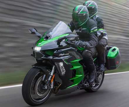 Bicicleta de turismo Kawasaki Ninja H2 SX 2025 acelerando descontroladamente na frente do terceiro quarto