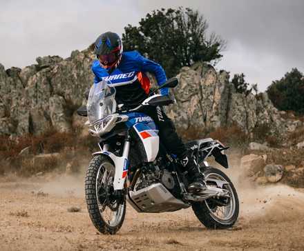 Foto frontal de uma Aprilia Tuareg deslizando em cascalho