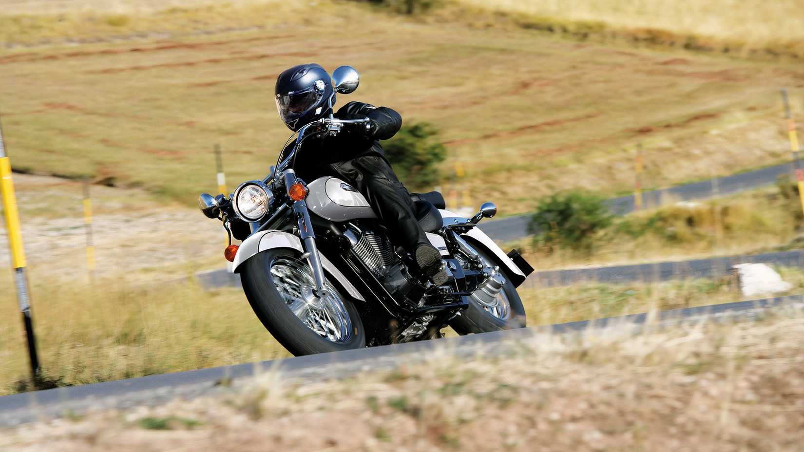 Honda Shadow cornering along a winding mountain road, front third quarter view