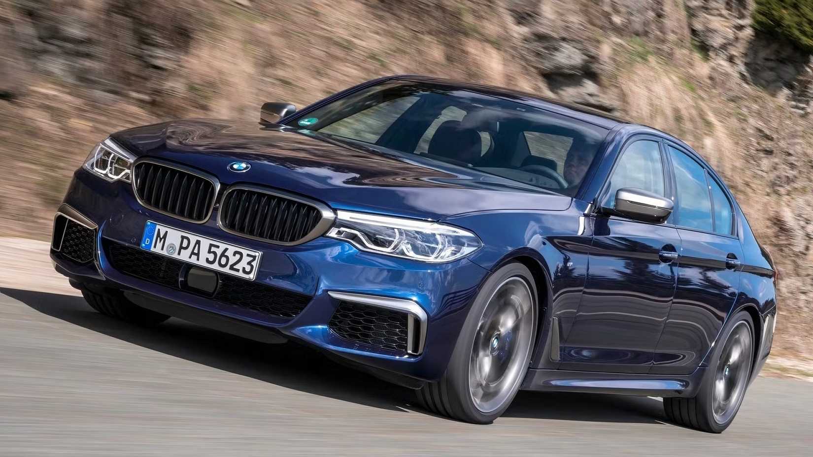 Front 3/4 view of blue 2018 BMW M550i xDrive driving.