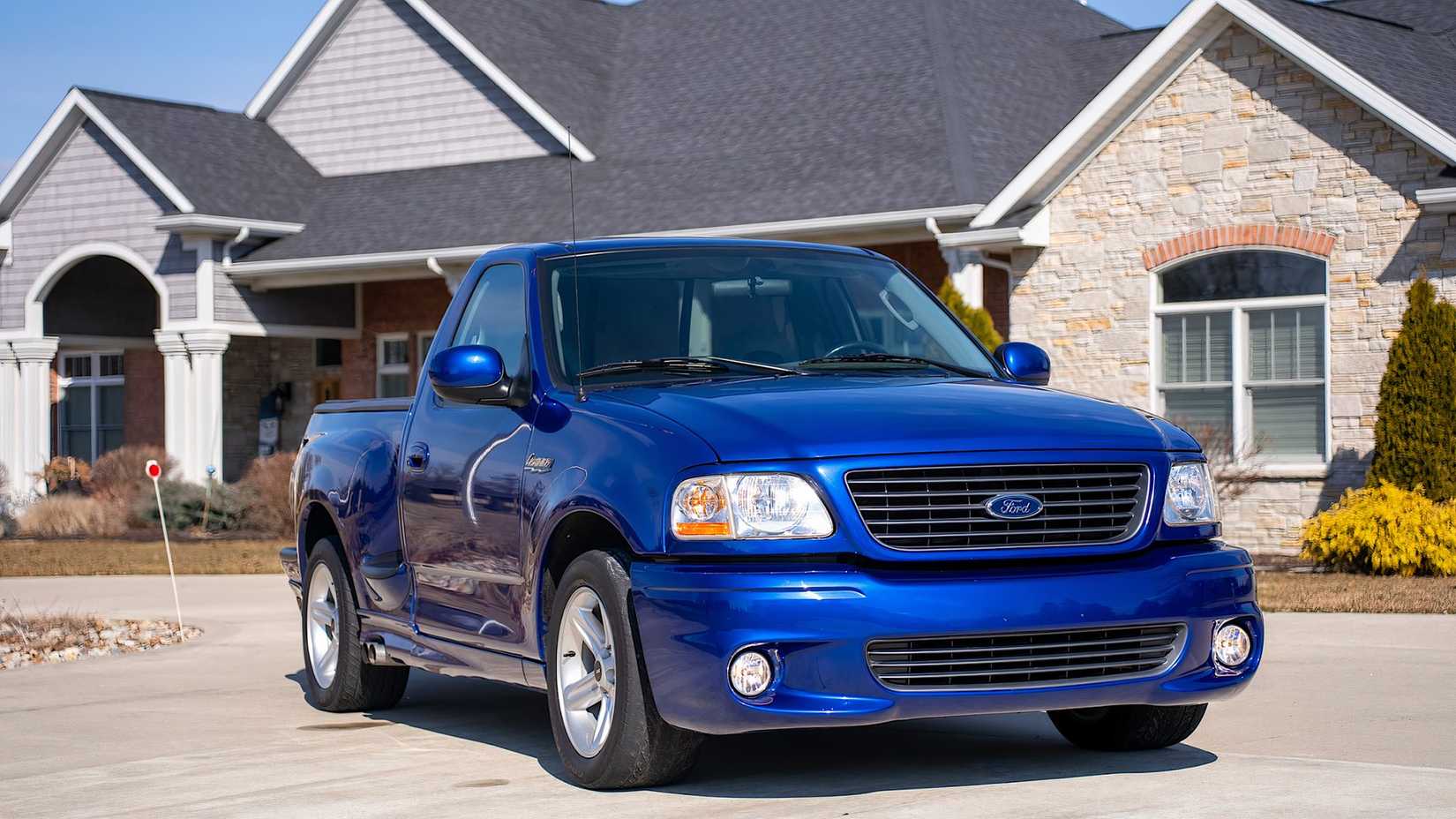 2004 Ford F-150 SVT Lightning in blue parked outside of house