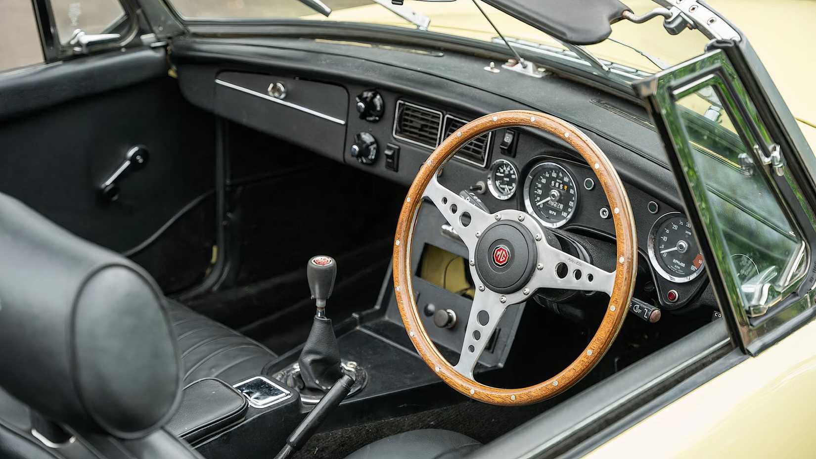 1975 MG B Roadster V8 interior showing front seats, dash, and steering wheel